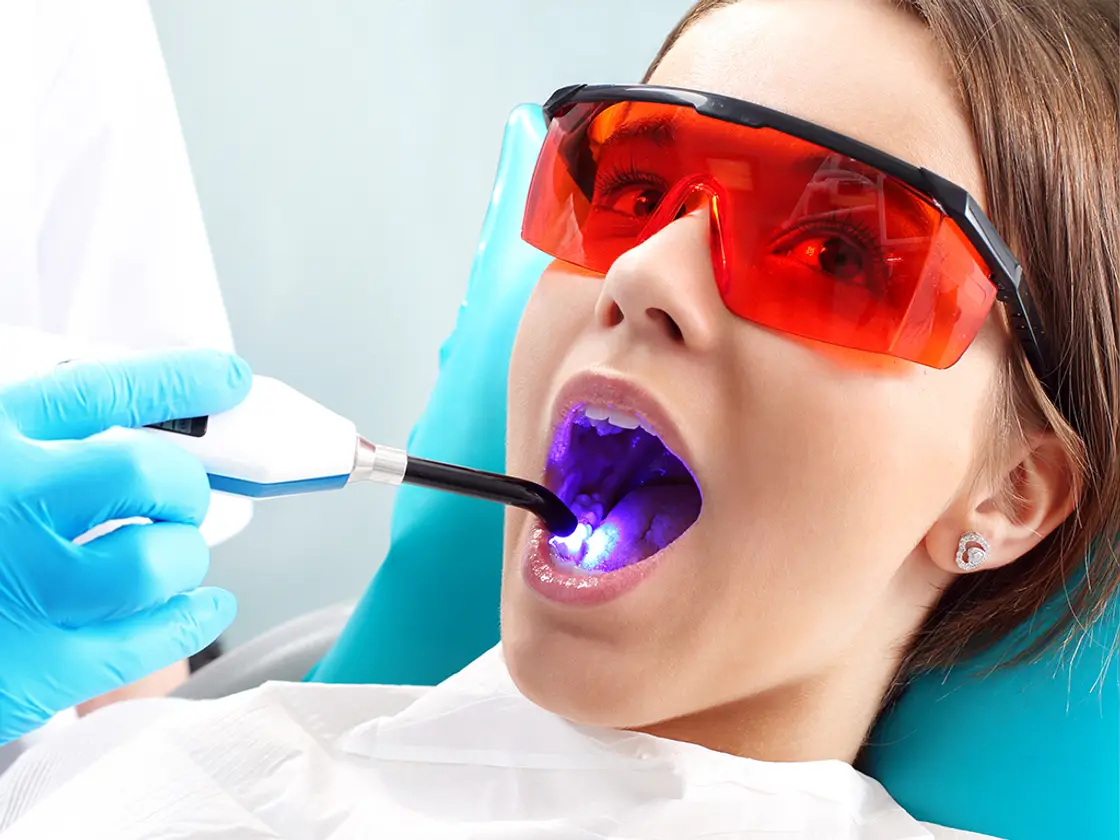 A patient wearing protective orange glasses during a treatment with a focused blue light