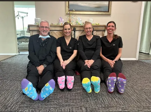 Dr. Kinney and three team members comparing Easter socks in the waiting room